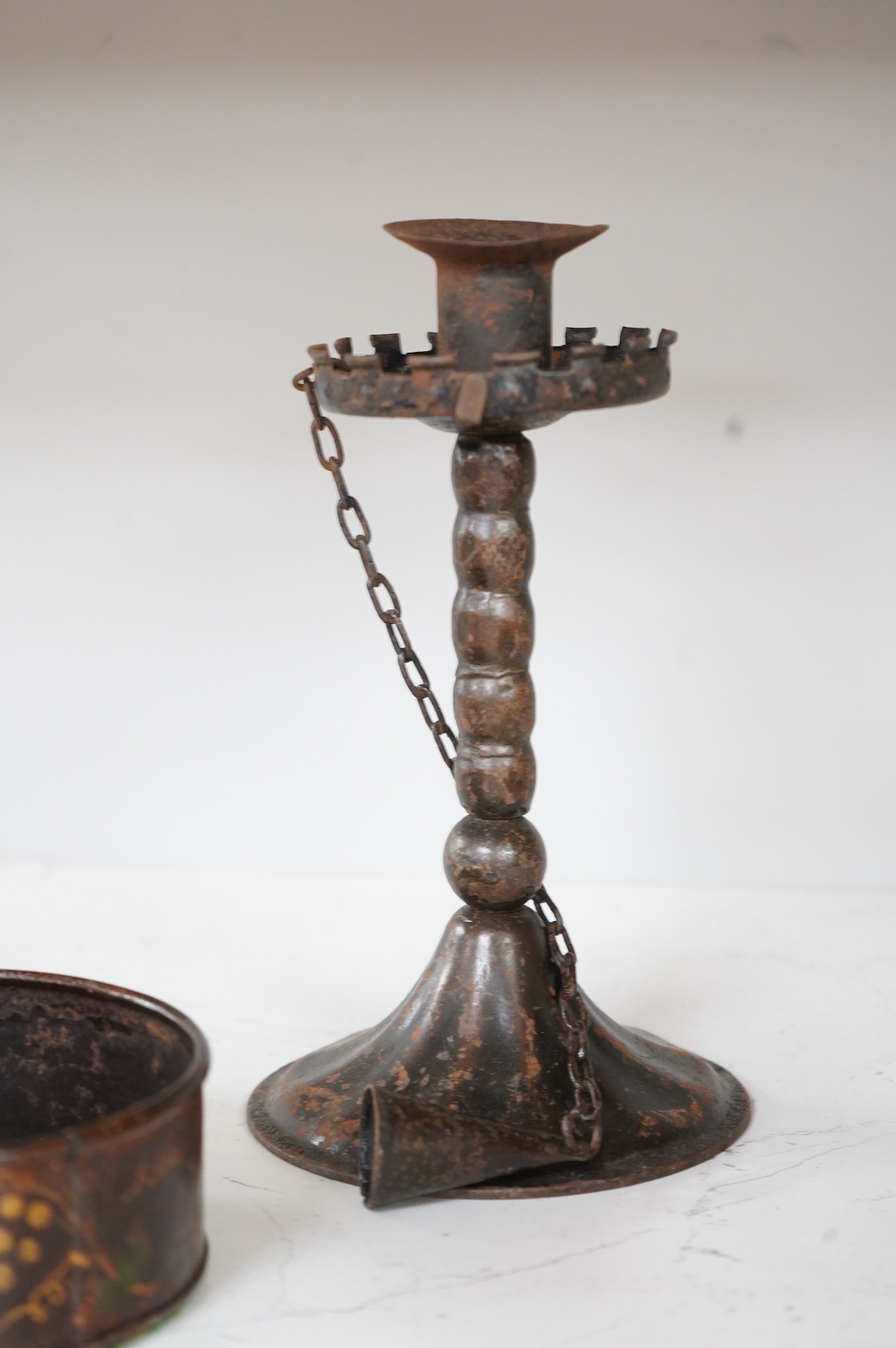 A pair of 19th century toleware wine coasters and an Arts & Crafts iron candlestick with attached snuffer, 21cm high